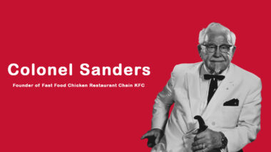 Colonel Sanders in his signature white suit holding a bucket of fried chicken