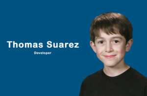 Young app developer Thomas Suarez coding on a MacBook, surrounded by devices