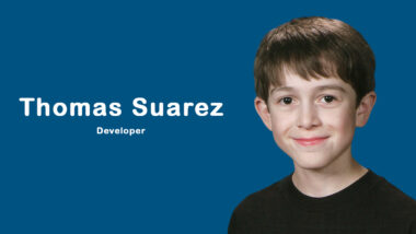 Young app developer Thomas Suarez coding on a MacBook, surrounded by devices